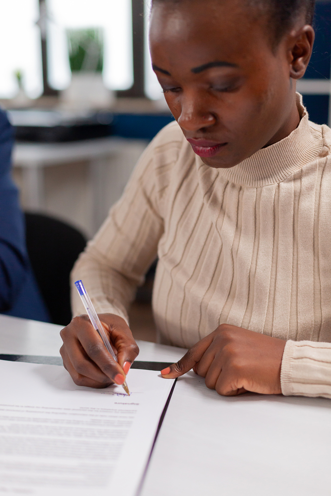 Woman signing family law litigation document Woman signing family law litigation document